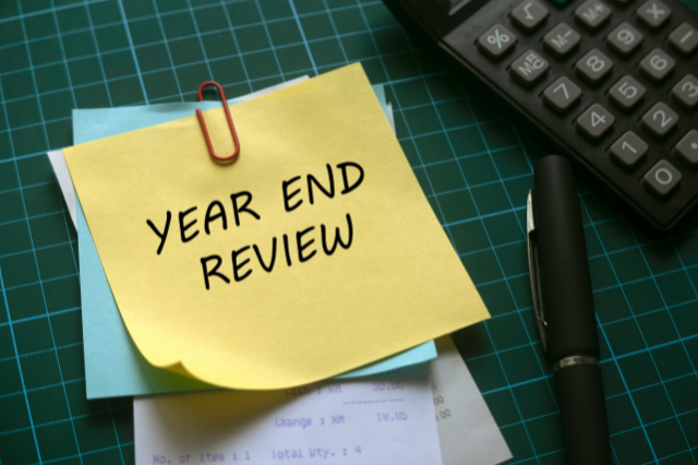 Image of a post it note with year end review on it
